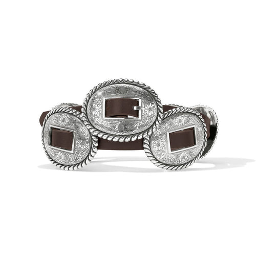 Brighton brown leather belt with oval silver-tone concho buckles featuring engraved floral and rope-edge detailing on a white background
