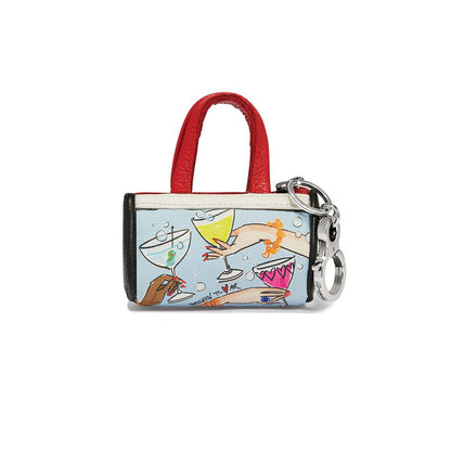 Brighton mini handbag key fob in leather with cocktail illustration print, red handles, and silver-tone clip on a white background