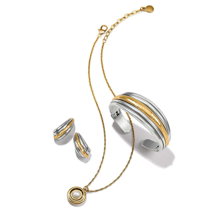 Brighton two-tone jewelry set styled with cuff bracelet, hoop earrings, and pearl pendant necklace on white background