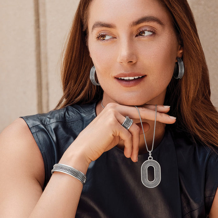 Model wearing Brighton silver-plated hoop earrings with matching openwork oval pendant necklace, ring, and cuff bracelet