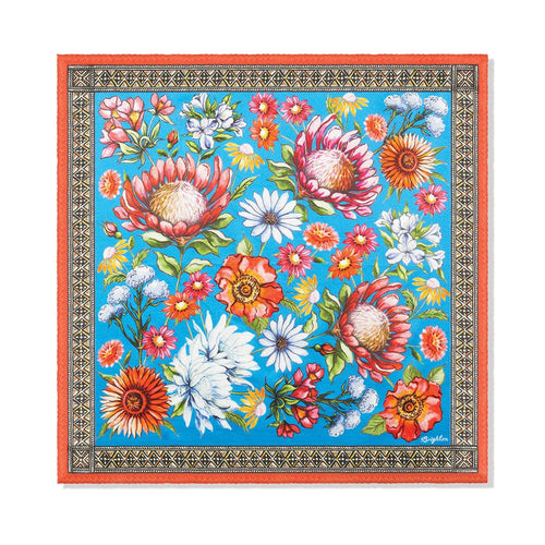 Brighton silk scarf with floral print of proteas, poppies, and daisies on blue with orange border on a white background