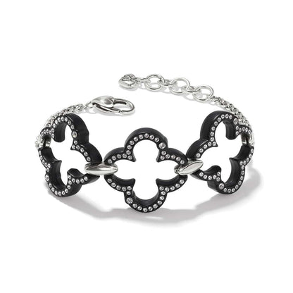 Brighton bracelet with black lacquer quatrefoil links, crystal accents, and silver-plated chain clasp on a white background