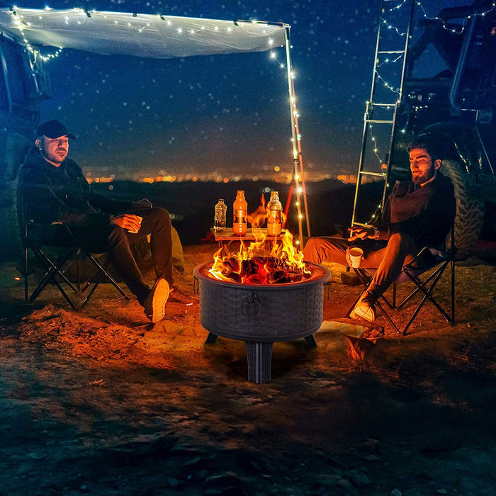 Two people sitting around a campfire at night with string lights and a ladder in the background.