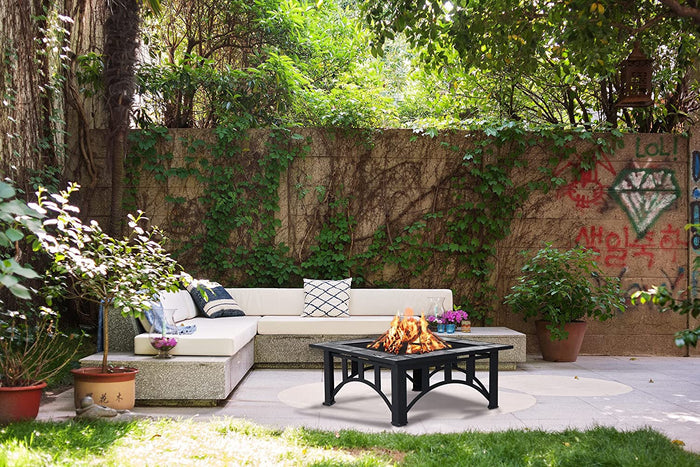 Outdoor patio with a sectional sofa and fire pit surrounded by greenery.