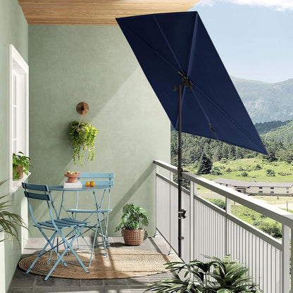 Rectangular flat patio market umbrella in navy blue, positioned over a small balcony table and chairs with a scenic view.