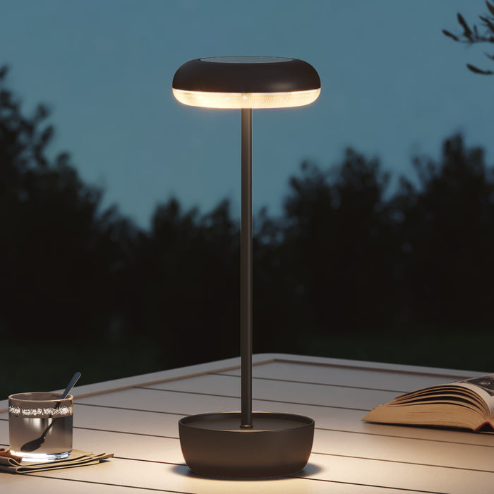 Modern outdoor lamp on a wooden surface with a dark background