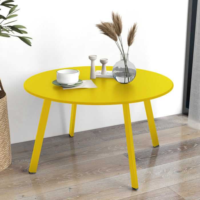 Yellow round table with decorative items on a wooden floor