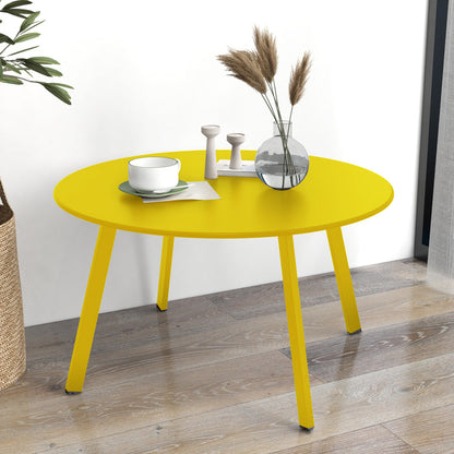 Yellow round table with decorative items on a wooden floor