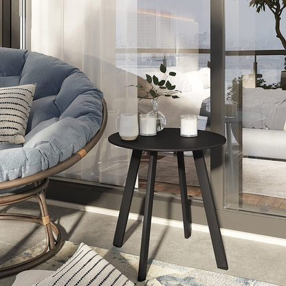 Modern living room with a black side table, round chair, and decorative elements.