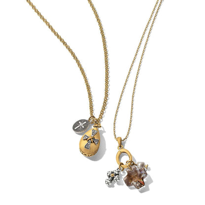 Brighton two-tone pendant necklaces with crystal cross charms, teardrop locket, and pearl accents on a white background