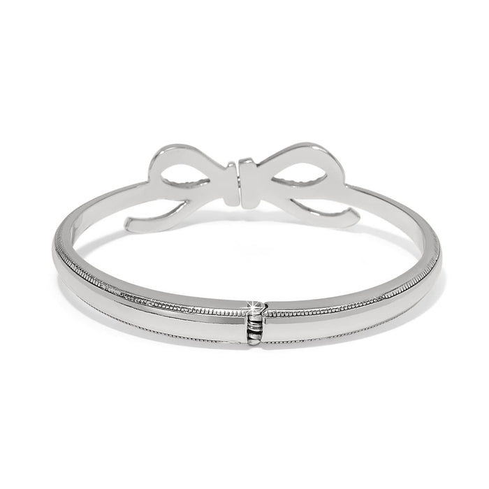 Brighton silver-plated bangle bracelet with bow accent and hinged opening shown from the back on a white background