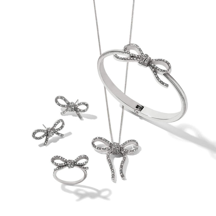 Brighton silver-plated bow jewelry set styled with matching crystal bangle, ring, earrings, and pendant necklace on white