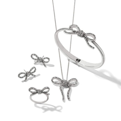 Brighton silver-plated bow jewelry set styled with matching crystal bangle, ring, earrings, and pendant necklace on white