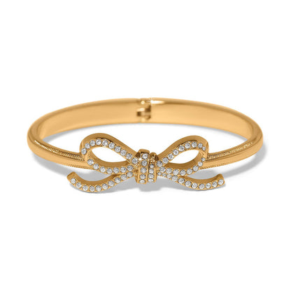 Brighton hinged bangle bracelet with gold-plated finish and crystal-encrusted bow centerpiece on a white background