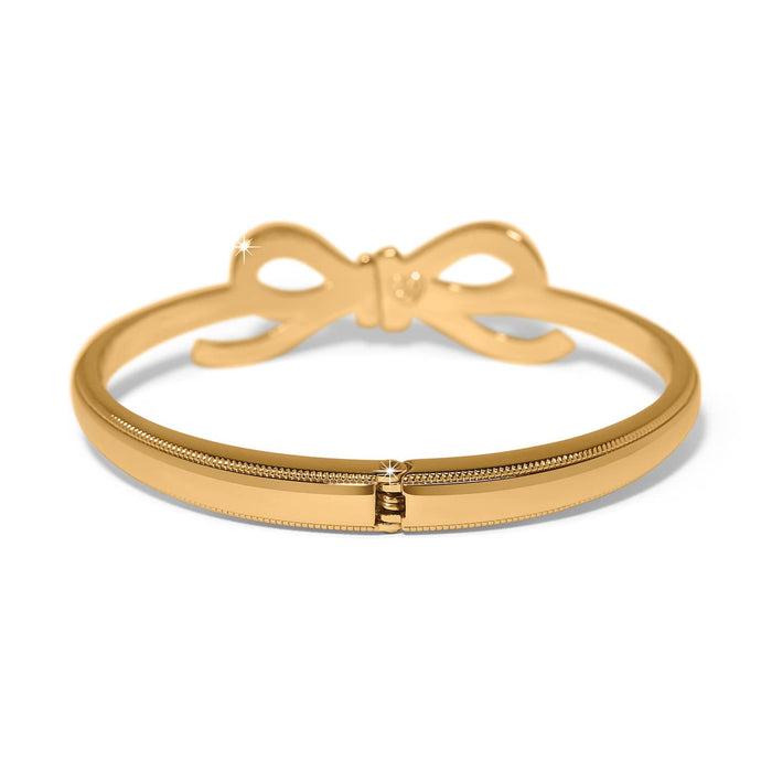 Brighton hinged bangle bracelet in gold-plated finish with bow detail and crystal accent on a white background