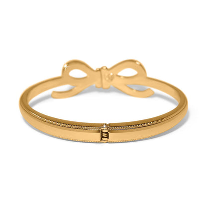 Brighton hinged bangle bracelet in gold-plated finish with bow detail and crystal accent on a white background