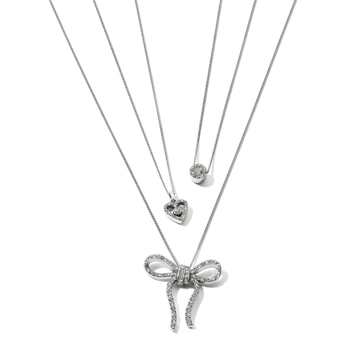 Brighton layered necklaces with silver-plated crystal bow, heart, and round pendants on a white background