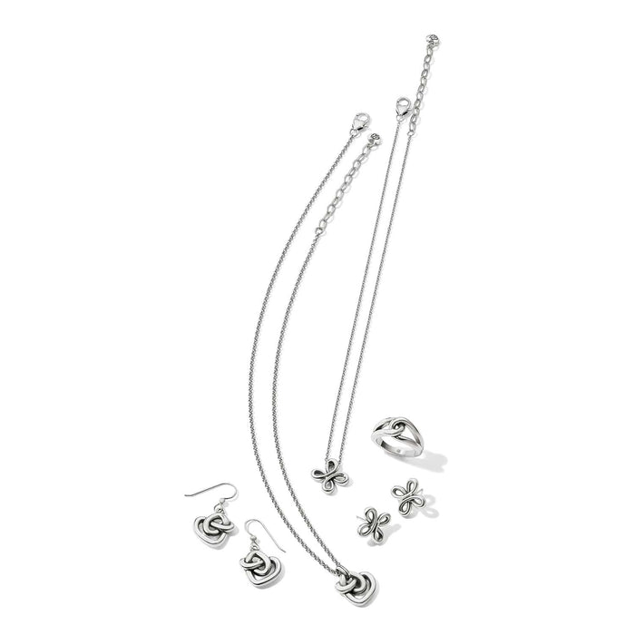 Brighton silver-plated jewelry set styled with knot-motif necklace, earrings, ring, and butterfly pendant on white background