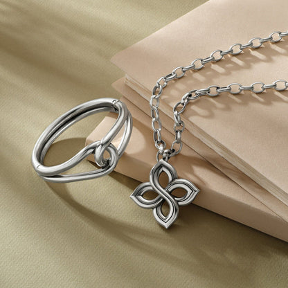Brighton silver-plated ring and floral pendant necklace styled with stacked notebooks on a neutral background