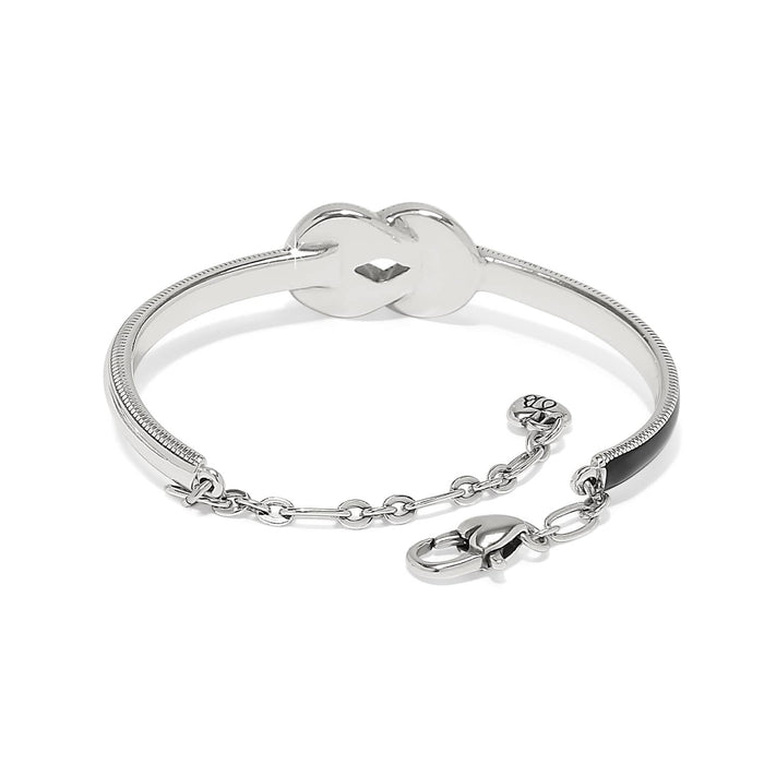Brighton silver-plated bangle bracelet with knot centerpiece, black enamel accent, and lobster clasp on a white background