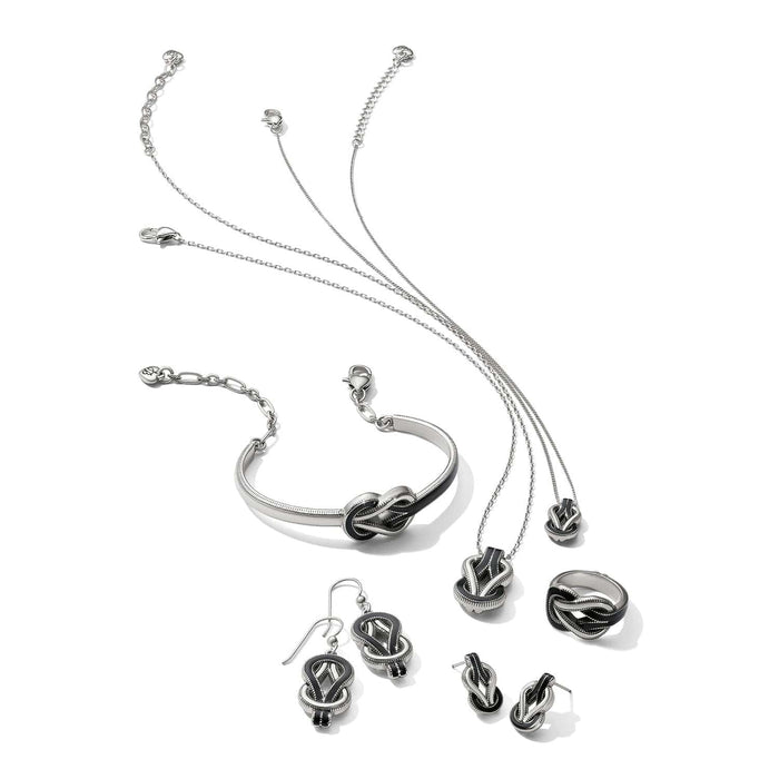 Brighton silver-plated jewelry set with black enamel knot motif featuring necklaces, bracelet, earrings, and ring on a white background