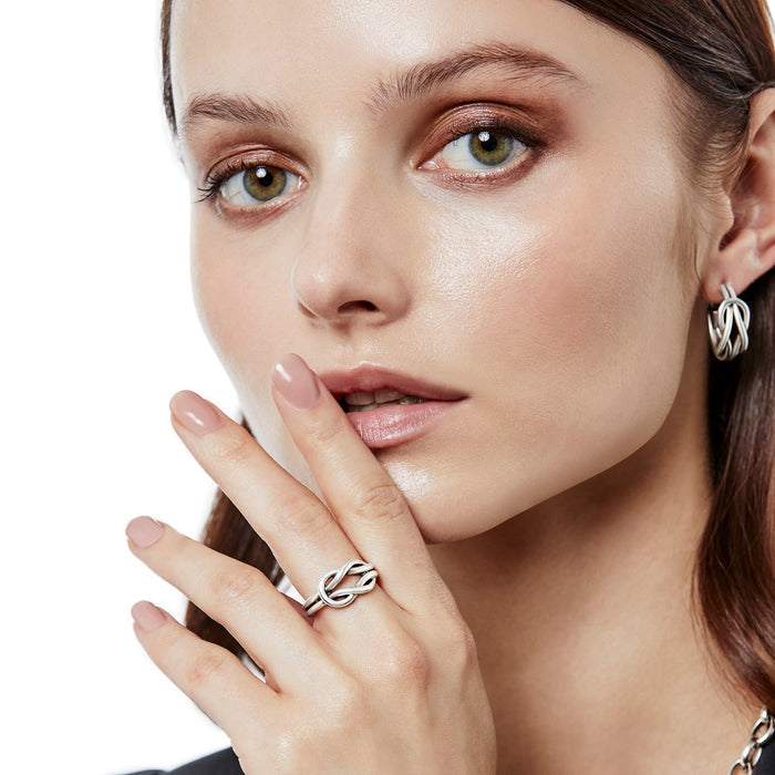 Model wearing a Brighton silver-plated knot ring paired with matching silver-plated knot hoop earrings