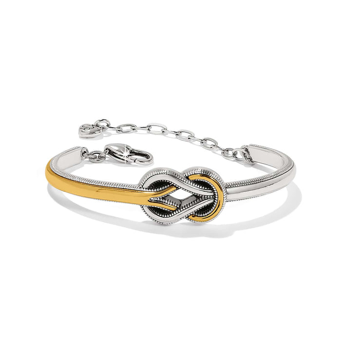 Brighton bangle bracelet with silver-plated and gold-tone interlocking knot centerpiece and lobster clasp on a white background