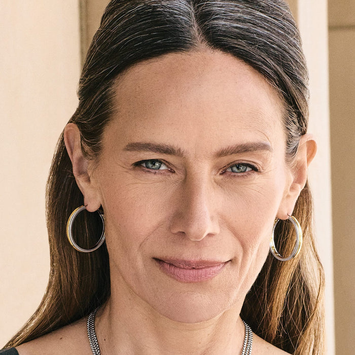 Model wearing Brighton hoop earrings with two-tone silver and gold finish and textured detailing
