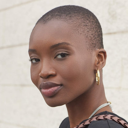 Model wearing Brighton two-tone hoop earrings with textured gold and silver detailing, styled with a Brighton silver chain necklace