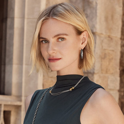 Model wearing Brighton silver-tone hoop earrings paired with a two-tone layered chain necklace with gold accents