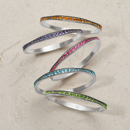 Brighton stacked bangle bracelets with orange, purple, pink, blue, and green crystal rows and silver-plated finish on a white background
