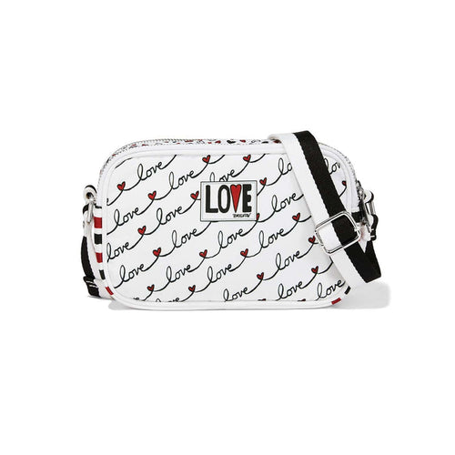 Brighton crossbody handbag with white love script print, red hearts, striped adjustable strap, and logo patch on a white background