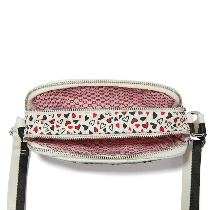 Close-up of Brighton handbag interior view showing red and black heart print lining with zippered compartments