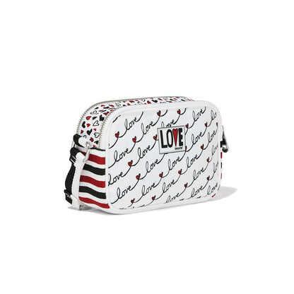 Brighton crossbody handbag with white love script print, red striped strap, and LOVE patch on a white background
