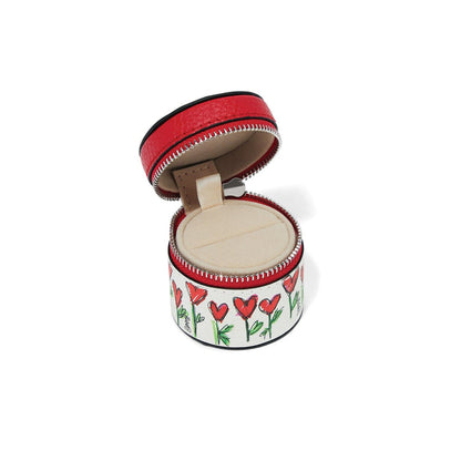 Brighton round leather jewelry case shown open with red interior and illustrated heart flower print on a white background