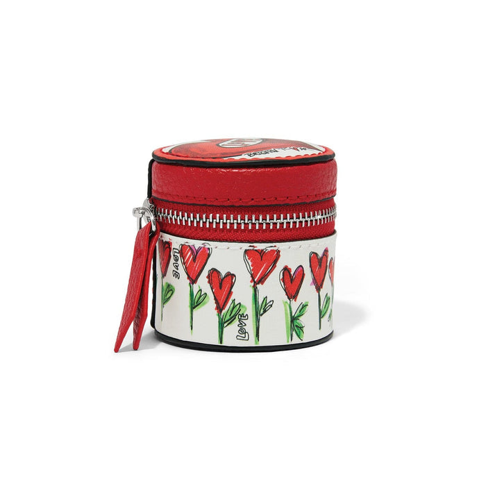 Brighton round leather jewelry case with red top, heart and floral print, and zip closure on a white background