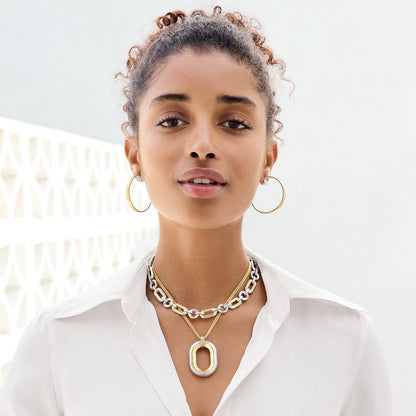 Model wearing Brighton two-tone layered link necklaces with hammered oval pendant and coordinating Brighton hoop earrings