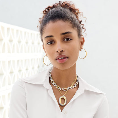 Model wearing Brighton two-tone hoop earrings with coordinating silver and gold layered chain link necklaces