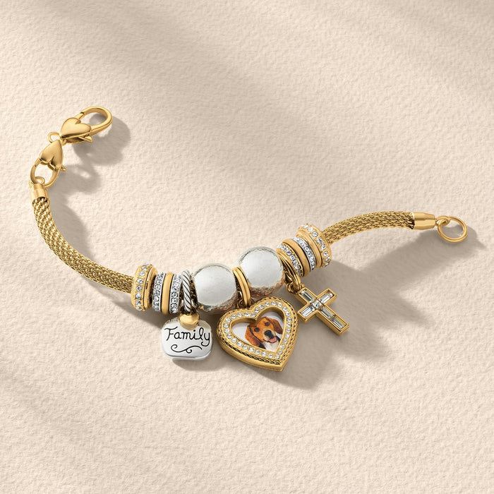 Brighton gold-plated mesh charm bracelet with crystal beads, Family tag, heart photo locket, and cross charm on a white background