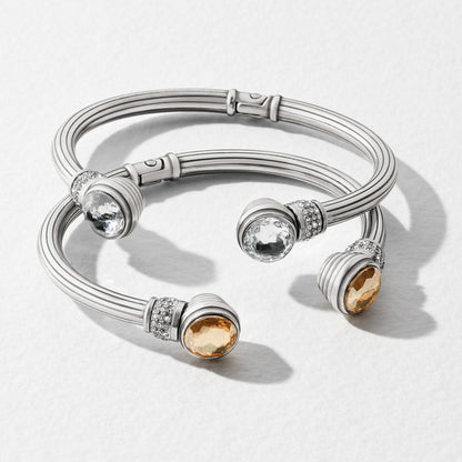 Brighton silver-plated hinged cuff bracelets with clear and amber faceted crystal ends and pavé accents on a white background
