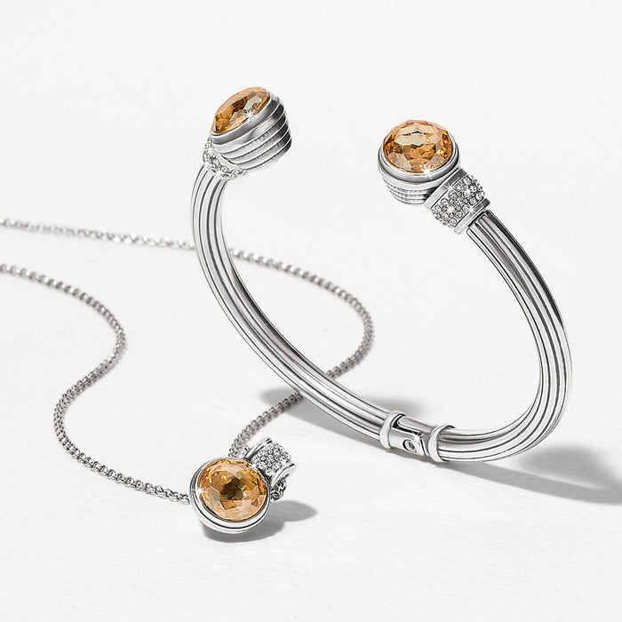 Brighton silver-plated cuff bracelet styled with a matching pendant necklace featuring amber crystals and pavé accents