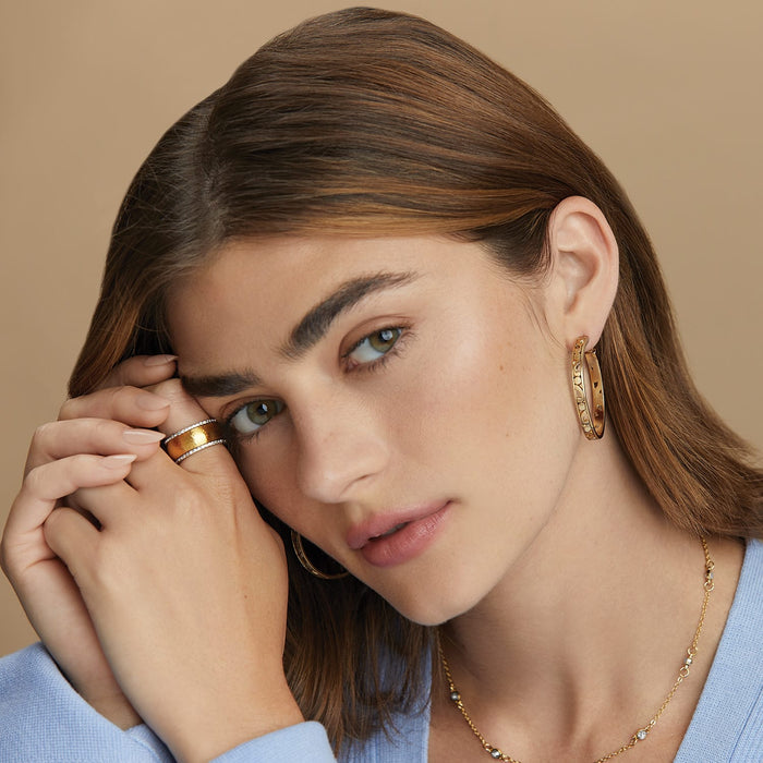 Model wearing Brighton gold-plated hoop earrings with coordinating gold-plated ring and crystal-accented necklace