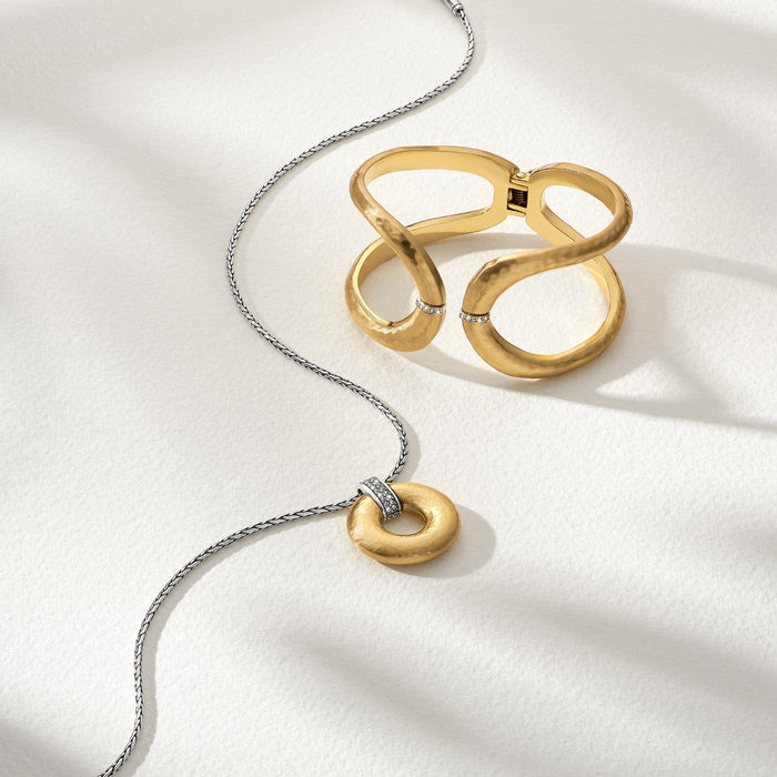 Brighton gold-plated pendant necklace and hinged cuff bracelet styled with crystal accents on a neutral background