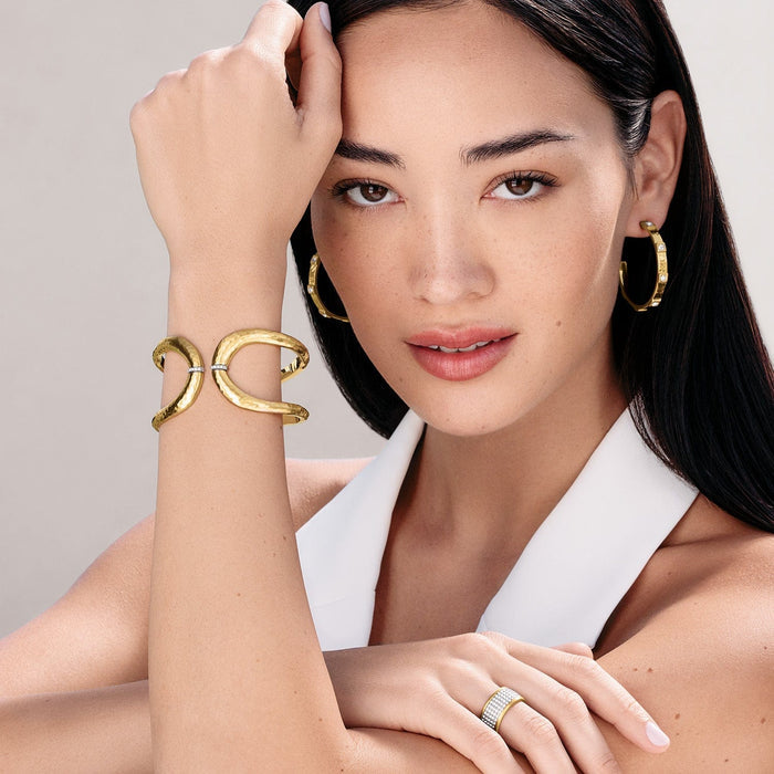 Model wearing a Brighton gold-plated hammered cuff bracelet with crystal accents and coordinating Brighton accessories