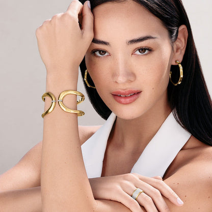 Model wearing a Brighton gold-plated hammered cuff bracelet with crystal accents and coordinating Brighton accessories
