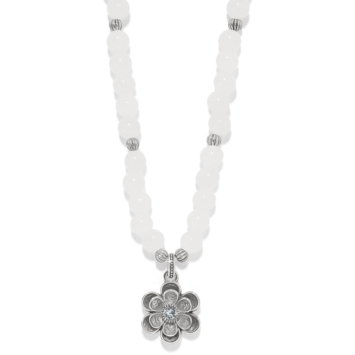 Brighton beaded necklace with white dyed jade beads and silver-plated flower pendant with crystal center on a white background