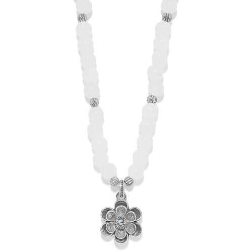 Brighton beaded necklace with white dyed jade beads and silver-plated flower pendant with crystal center on a white background