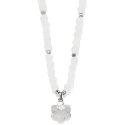 Brighton beaded necklace with white dyed jade beads and silver-plated flower pendant on a white background