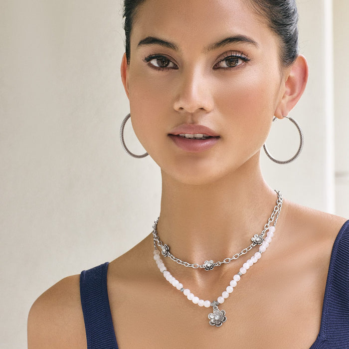 Model wearing a Brighton silver-plated layered necklace with white dyed jade beads and floral crystal accents