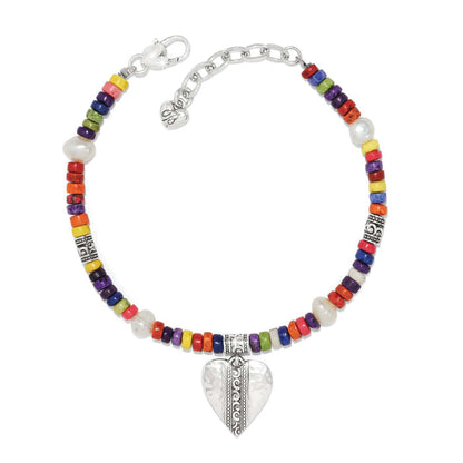 Brighton beaded bracelet with multicolored heishi beads, potato pearls, silver-plated heart charm and clasp on a white background